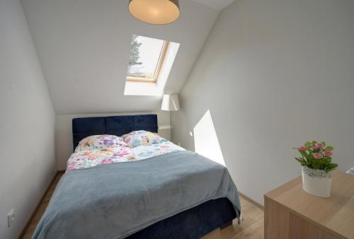 um pequeno quarto com uma cama azul e uma janela em Apartament Sun & Ski Weekend Willa Nad Łomnicą 15 - centrum 100m em Karpacz