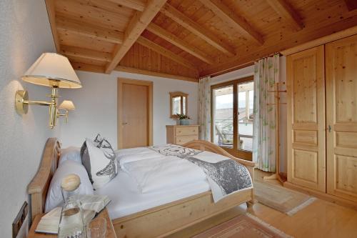 1 dormitorio con cama y techo de madera en Appartementhaus Kostenzer, en Fügen