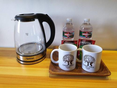 two coffee mugs sitting on a wooden tray next to a blender at CAMP TREEHOUSE • COTTAGE • POOL • JACUZZI in Antipolo