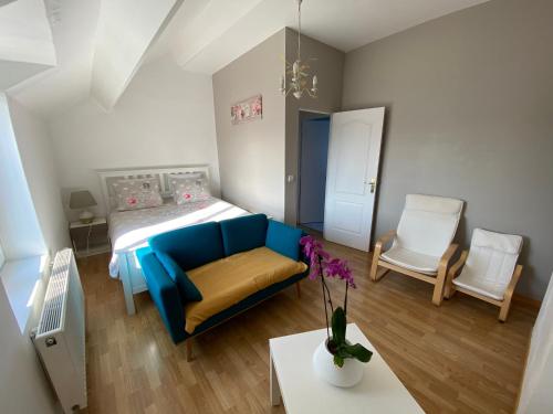 Cette petite chambre dispose d'un canapé bleu et d'un lit. dans l'établissement J & C vacation home 8 minutes by car to Disneyland, à Montry