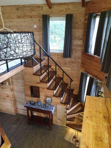a spiral staircase in a wooden cabin with a table at CAMP TREEHOUSE • COTTAGE • POOL • JACUZZI in Antipolo