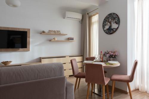 een woonkamer met een tafel en stoelen en een bank bij Apartament Le Bonheur in Mamaia