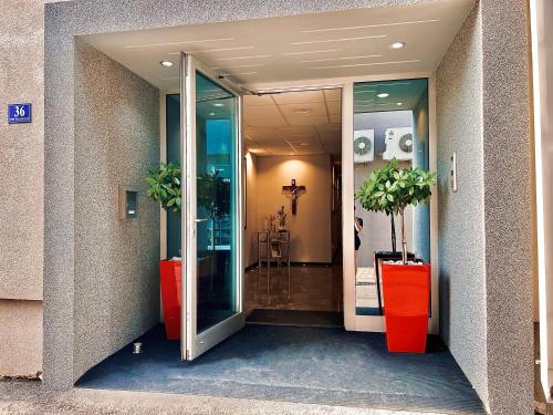 an entrance to a building with two potted plants at Hotel Frankoni in Međugorje