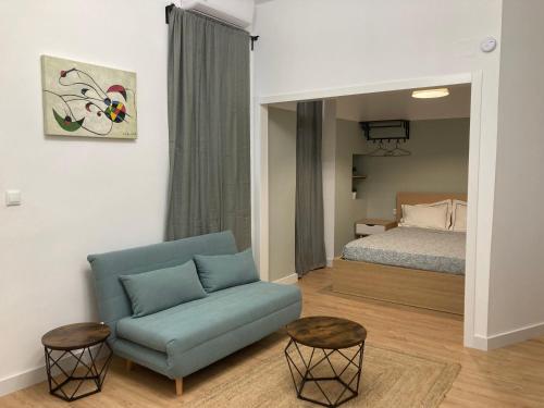 sala de estar con sofá azul y cama en Castle View Apartments, en Alicante