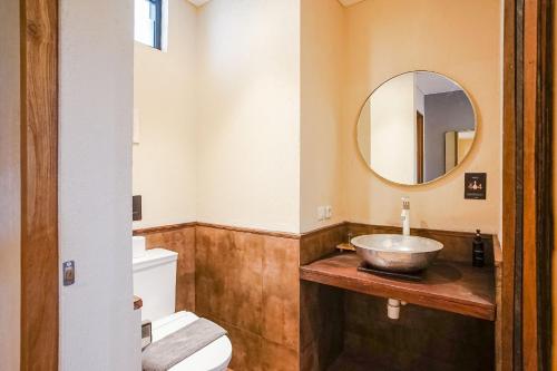 a bathroom with a bowl sink and a mirror at Tanaga CoLiving in Seminyak