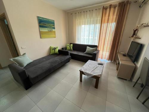 a living room with a couch and a tv at Miloen Residence Gjiri I Lalzit in Durrës