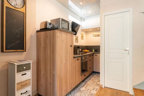 - une cuisine avec un four micro-ondes au-dessus d'une armoire en bois dans l'établissement Cajem, à Étretat