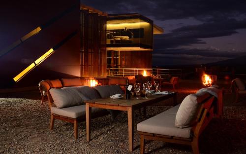 a room with a table and chairs and a building at Casa de Uco Vineyards and Wine Resort in Los Árboles