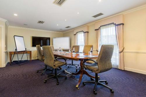 a conference room with a wooden table and chairs at Canterbury International Hotel in Forest Hill