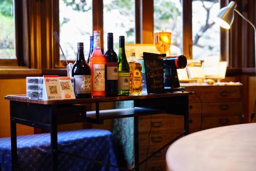 uma mesa com garrafas de vinho e um copo em Yamada Bessou em Beppu