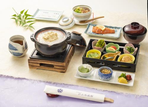a table with a pot of food on a stove at 京都駅前ひふみ旅館（HifumiRyokan Kyoto station) in Kyoto