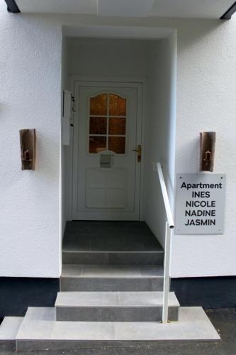 a white door with a sign in front of it at Appartement Eveline in Velden am Wörthersee