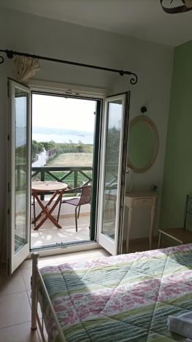 a bedroom with a bed and a balcony with a table at Magic Land in Plaka