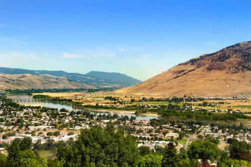 a town with a river and mountains in the background at Knights Inn Kamloops in Kamloops