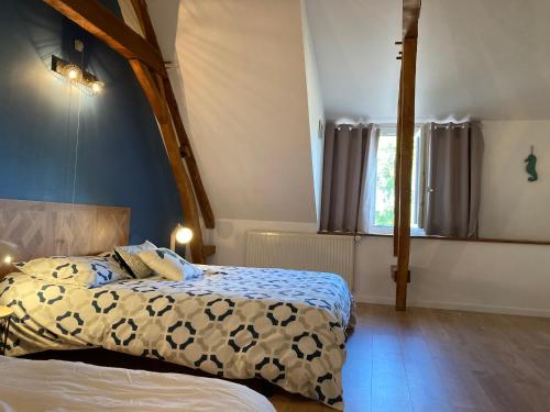1 dormitorio con 2 camas y pared azul en Chambres dhotes a la ferme en Forest-Montiers