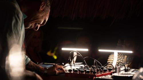 a man is sitting at a table with a keyboard at BLACK AMBER BOUTIQUE HOTEL in Lampi