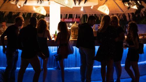 a group of people standing in front of a bar at BLACK AMBER BOUTIQUE HOTEL in Lampi