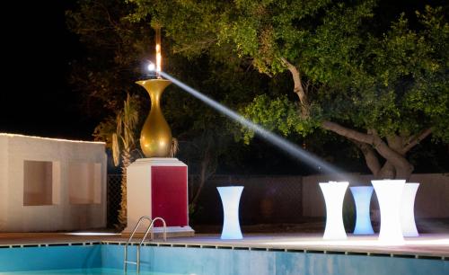 a lit candle in a large vase next to a pool at BLACK AMBER BOUTIQUE HOTEL in Lampi