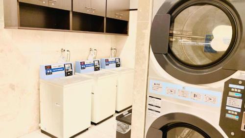 a washing machine in a laundry room with two counters at Toyoko Inn Shiki eki Higashi guchi in Shiki