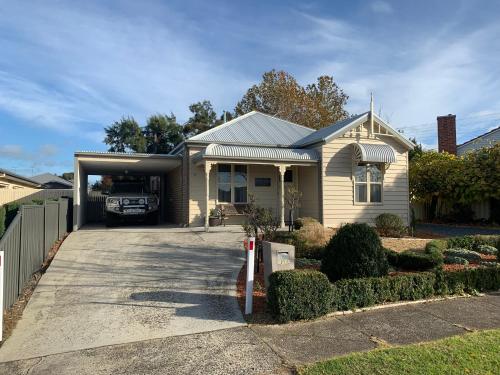 a house with a garage with a truck in it at Elmsford Cottage in Warragul
