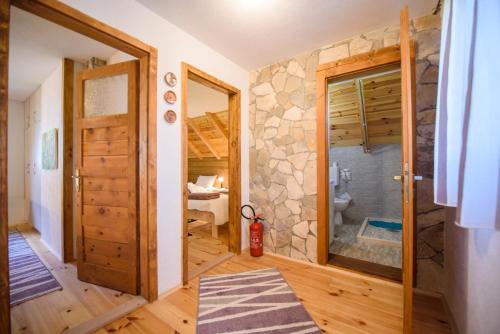a bathroom with a walk in shower next to a door at Sterling Lodge in Kolašin