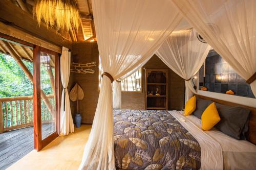 a bedroom with a bed with a canopy at Bamboo Turtles Ecolodge in Ubud