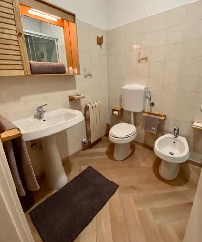 a bathroom with a sink and a toilet and a mirror at HOTEL LE FONTI in Lurisia