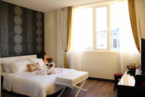 - une chambre avec un lit blanc et une grande fenêtre dans l'établissement Orchid Hotel, à Hue
