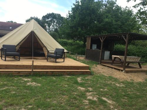 Jurte mit zwei Stühlen und einer Bank auf einer Terrasse in der Unterkunft Le Petit Chaumont Ecolodge in Chaumont