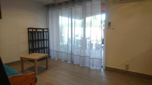 - un salon avec une fenêtre dotée de rideaux et d'une table dans l'établissement Appartements dans résidence Avec piscine - Mer à 500m, à Sainte-Marie-la-Mer