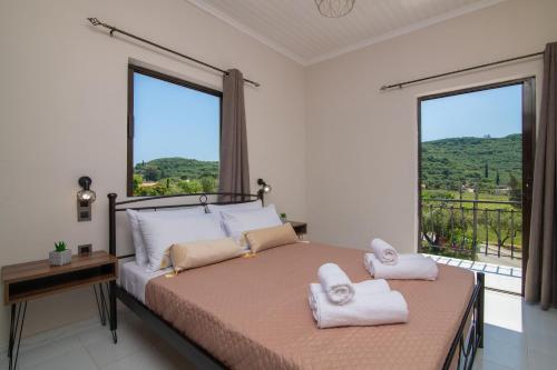 a bedroom with a bed with two towels on it at Arokaria apartment in Alikanas