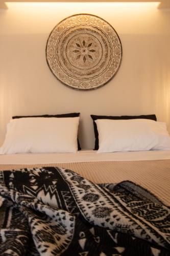a bed with a blanket on it with a picture on the wall at Aotés in Naxos Chora