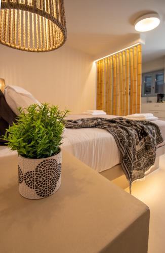 a bedroom with a bed and a potted plant on a table at Aotés in Naxos Chora