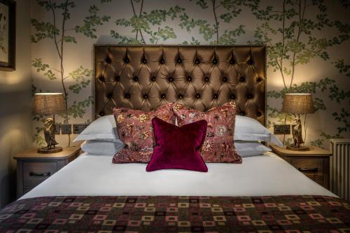een slaapkamer met een groot bed met rode kussens bij The Millstone, Mellor in Blackburn