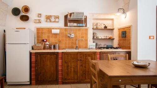 オストゥーニにあるCasa Colombo & Casa Scipione by Rentbeatのキッチン(白い冷蔵庫、テーブル付)