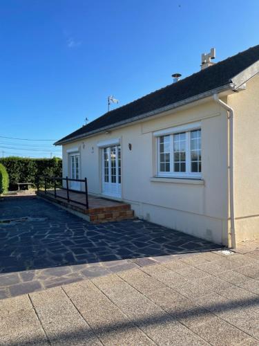 a white house with a driveway in front of it at Asinellas maison 3 chambres 150 m de la plage in Asnelles