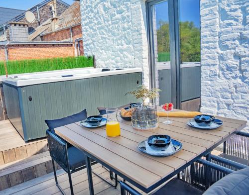 a wooden table on a balcony with a meal on it at Gatsby River II in Yvoir