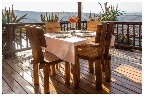 a wooden table and chairs on a deck at Leopards and Louries Bush Lodge in Camperdown