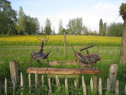 two deer statues on a fence in a field at Vakantiehuis in de velden met zwemvijver en Jeu de Boules baan in Lier