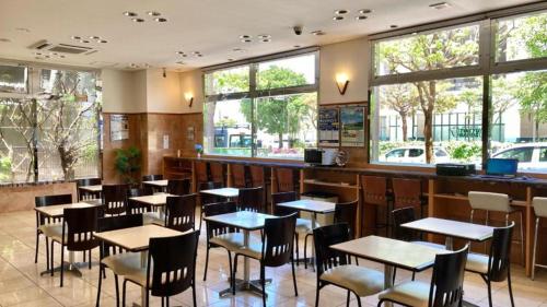 那覇市にある東横INN那覇新都心おもろまちのテーブルと椅子、窓のあるレストラン