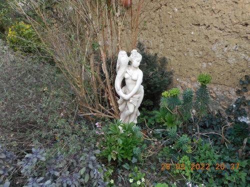 a statue of a woman sitting in a garden at Le Gite de Lili in Acquigny
