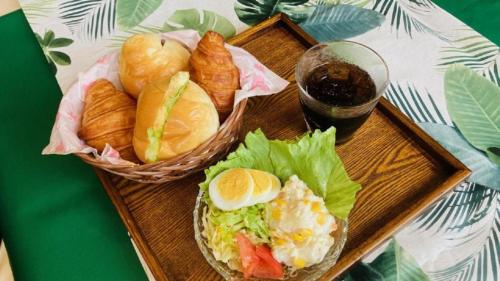 a wooden tray with sandwiches and croissants and a glass of soda at Toyoko Inn Okinawa Naha Shintoshin Omoromachi in Naha