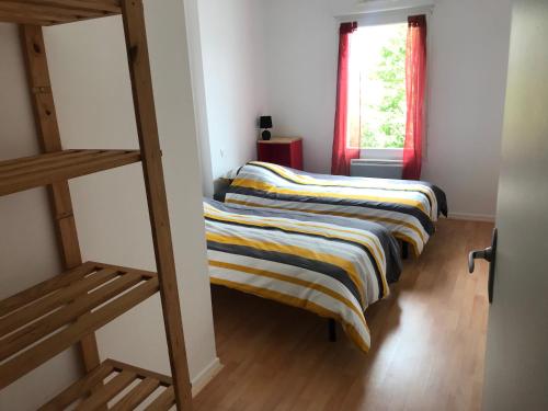 two bunk beds in a room with a window at Appartement + Jardin in Fouesnant