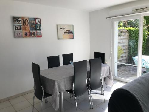 une salle à manger avec une table et des chaises dans l'établissement Appartement + Jardin, à Fouesnant
