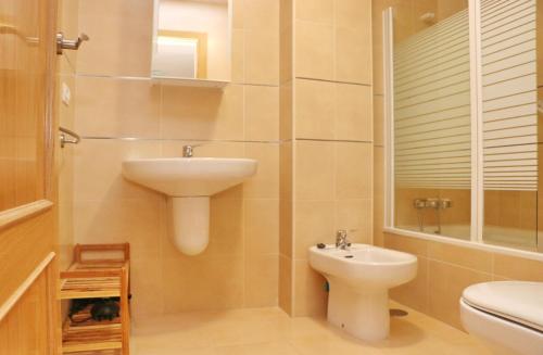 ein Bad mit einem Waschbecken und einem WC in der Unterkunft Apartamento Río Salado in Conil de la Frontera