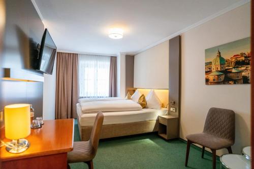 ein Hotelzimmer mit einem Bett, einem Tisch und Stühlen in der Unterkunft Cityhotel Trumer Stube in Salzburg