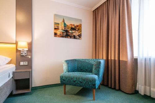 a room with a blue chair in a hotel room at Cityhotel Trumer Stube in Salzburg