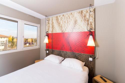 a bedroom with a bed and a window at Ibis Toulouse Purpan Aeroport in Toulouse
