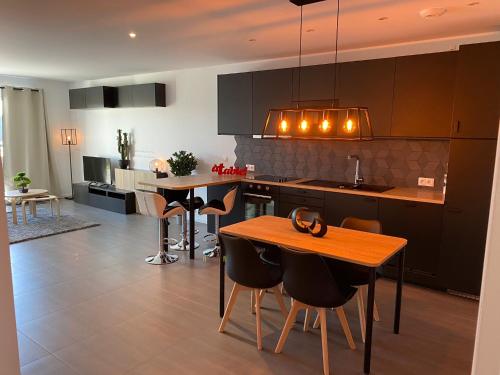 a kitchen with a table and some chairs in it at GOLD COCOON T3 74m2 proche centre ville in Villejust