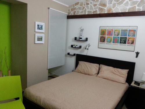 - une chambre avec un lit et un mur vert dans l'établissement Villa La fenice, à Granelli